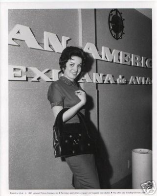 1957 A woman posing by the Los Angeles Airport Pan Am ticket counter.